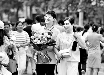 6月16日，在安徽省阜阳市红旗中学考点外，家人给孩子送上鲜花。卢启建摄/光明图片