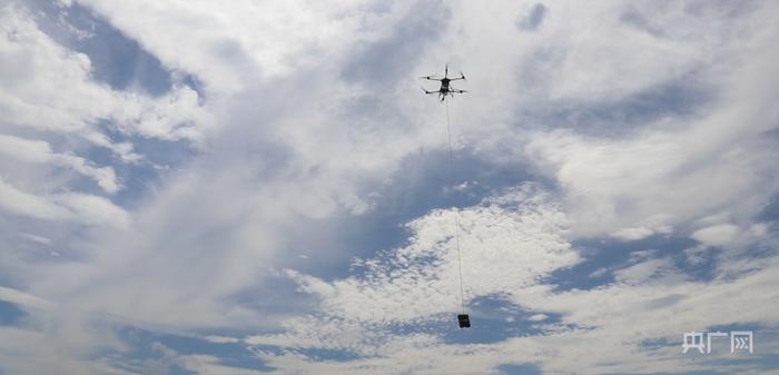 无人机吊起50公斤货物箱（央广网见习记者 郇康新 摄）