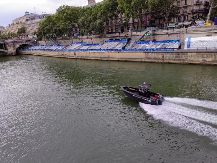   塞纳河上巡逻的警用快艇，沿岸座位已搭建完毕。新华社记者 岳冉冉 摄