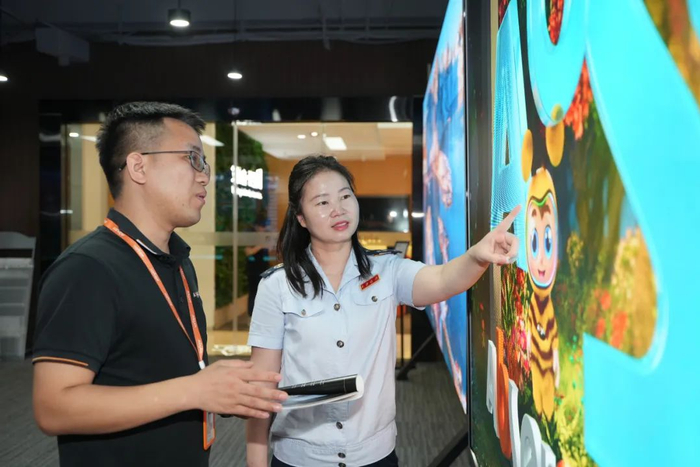 深圳市龙岗区税务局“语税人”团队成员在艾比森光电股份公司了解产品研发情况。林建荣 麻晓璇 摄