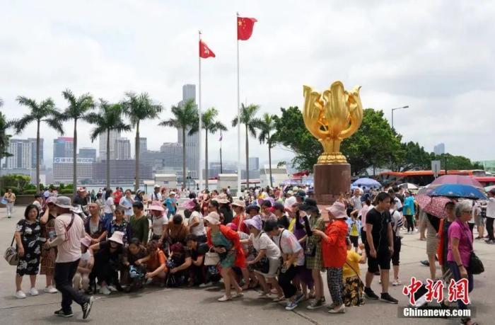 资料图：众多内地游客在香港金紫荆广场观光拍照。中新社记者 张炜 摄