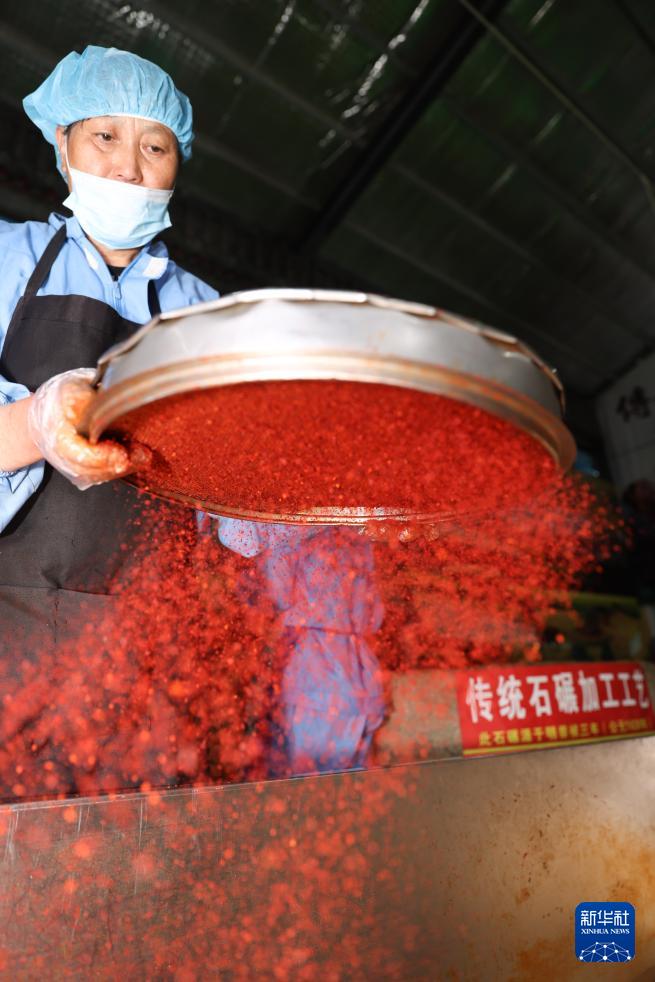   7月22日，工作人员在甘肃天水市甘谷县安远镇大城村的辣椒烘干和加工车间给辣椒粉过筛。 新华社记者 吕帅 摄