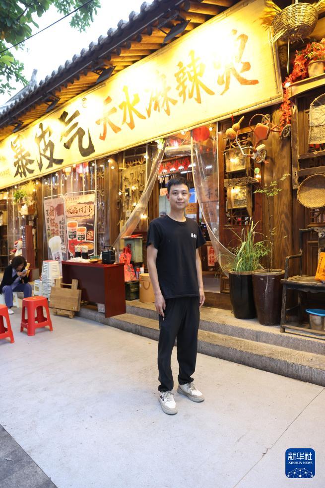   7月22日，经营麻辣烫店10多年的商户郝二龙在甘肃天水古城的一家麻辣烫店门前。 新华社记者 吕帅 摄