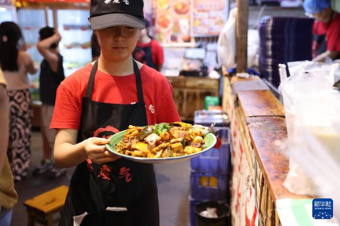   7月22日，工作人员在甘肃天水古城的一家麻辣烫店上菜。 新华社记者 吕帅 摄