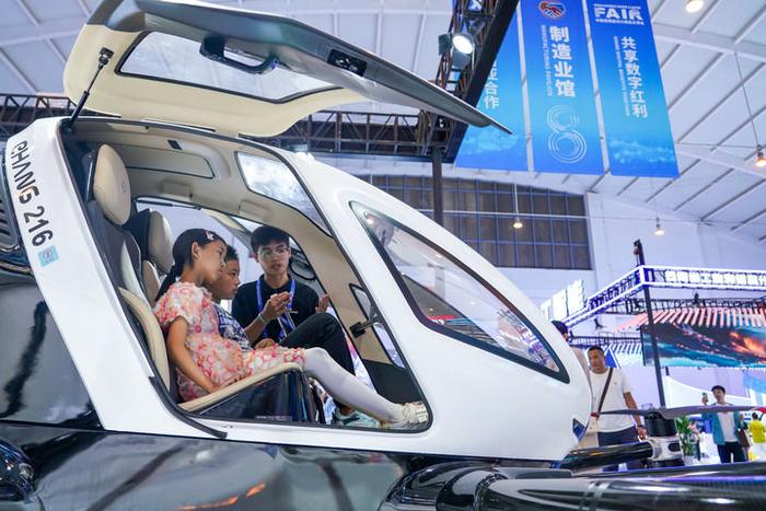小朋友在南博会上了解无人驾驶载人航空器（2024年7月25日摄）。新华社记者 王静颐 摄