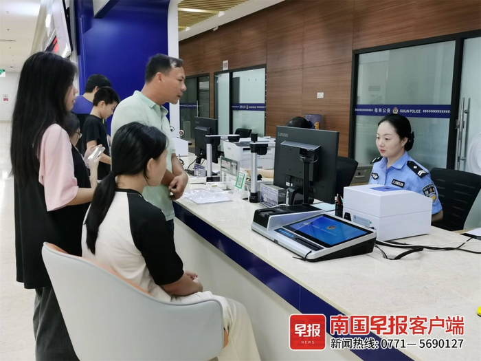 ▲在桂林市政务服务中心公安政务服务厅的“一窗通办”窗口，民警为市民办理业务。记者 颜强 摄