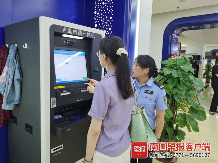 ▲民警帮助市民通过自助申请一体机办理业务。记者 颜强 摄