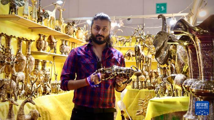 7月23日，巴基斯坦参展商阿基夫展示铸铜雕刻手工艺品。新华社记者 王贤思 摄