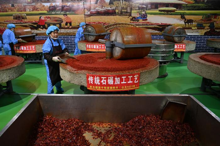   在天水市甘谷县安远镇大城村的一家企业，工人用电动石碾加工辣椒面。新华社记者 范培珅 摄