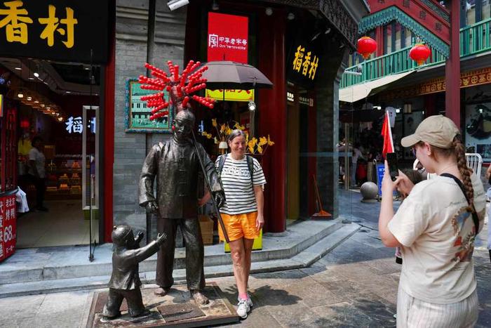   7月10日，两名来自瑞士的游客在北京前门大街拍照留影。新华社记者 鞠焕宗 摄