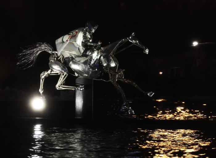 ↑女骑手弗洛里亚娜·伊塞尔身披奥林匹克五环旗沿着塞纳河“疾驰”。新华社记者 陈斌 摄