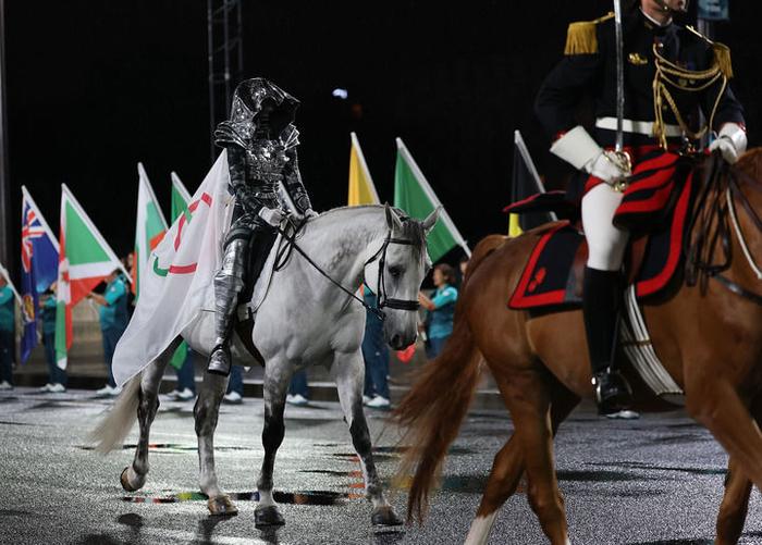 ↑女骑手弗洛里亚娜·伊塞尔身披奥林匹克五环旗进入特罗卡德罗广场。  新华社记者 李明 摄