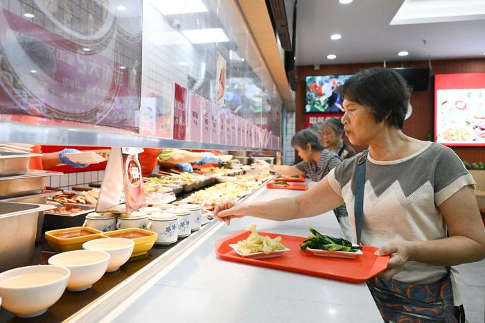 老人正在广州桐乐社区饭堂挑选餐品（7月24日摄）。新华社记者 李贺 摄