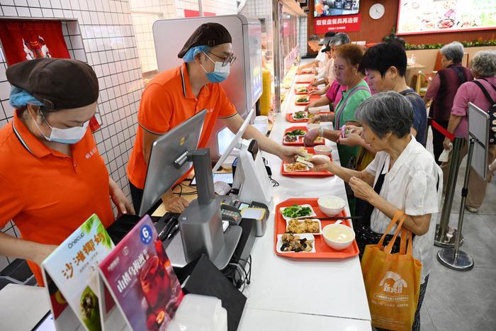 老人正在广州桐乐社区饭堂挑选餐品（7月24日摄）。新华社记者 李贺 摄