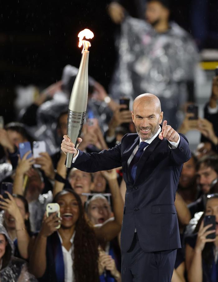 ↑法国前职业足球运动员齐达内在开幕式现场传递火炬。新华社记者 李颖 摄