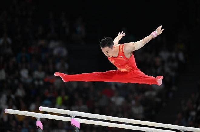 7月27日，中国选手邹敬园在双杠比赛中。新华社记者 程敏 摄