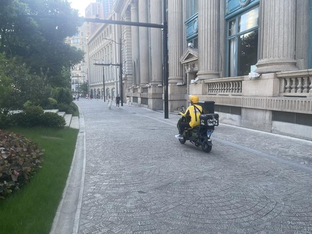 北苏州路弹格路上飞驰而过的外卖小哥。 王海燕摄