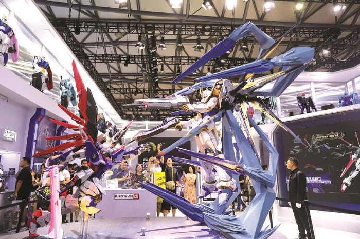    第二十一届中国国际数码互动娱乐展览会在上海新国际博览中心举行，图为参观者在一组大型机器人模型情景展示台前驻足观看。  