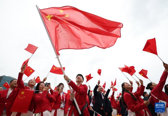 7月26日，中国体育代表团旗手、乒乓球选手马龙在开幕式前挥舞国旗。新华社记者 曹灿 摄