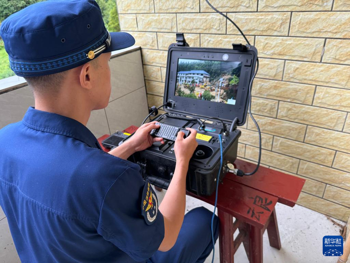 7月28日，湖南省消防救援总队应急通信保障前突小组成员梁世鑫在使用卫星便携智慧箱实时传输现场画面。新华社记者 张格 摄