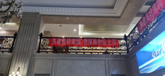 北湖壹号售楼处横幅“共建美好家园 迎接新物业公司”。 董红艳/摄
