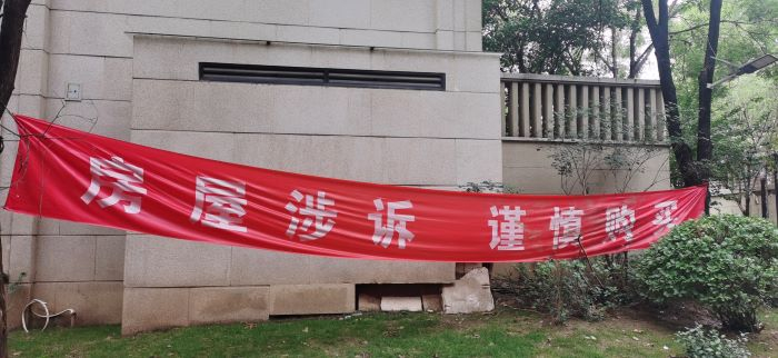 北湖壹号小区内部悬挂着“房屋涉诉 谨慎购买”的横幅。 董红艳/摄