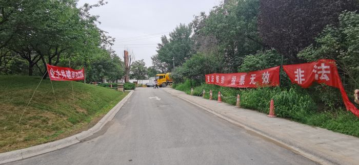 北湖壹号大门前方业主的横幅（左）和物业的横幅（右）对峙。 董红艳/摄