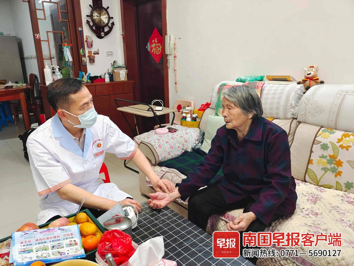 ▲金秀瑶族自治县家庭签约医生上门为老年居民把脉问诊。自治区卫生健康委供图