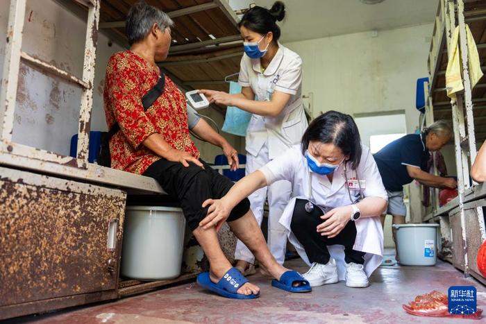   7月30日，在湘潭县河口中学安置点，医务人员为转移安置的群众检查身体。新华社记者 陈思汗 摄