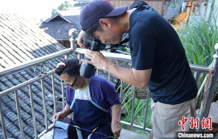 近日，日本摄影师竹田武史在贵州省从江县岜沙苗寨拍摄正在刺绣的老人。　周燕玲 摄