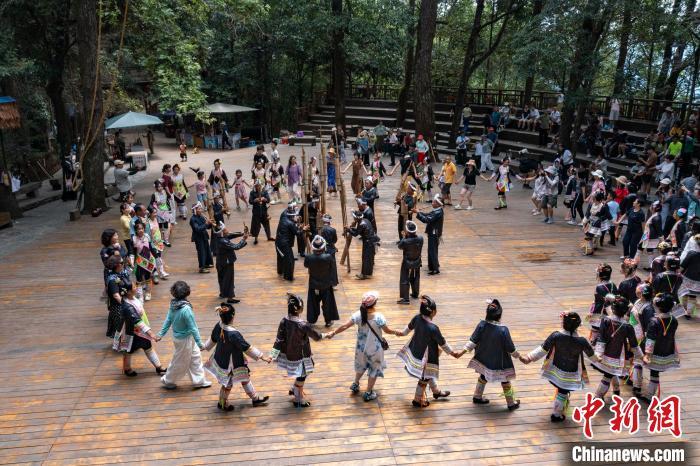 7月23日，游客在贵州省从江县丙妹镇岜沙苗寨参与民族舞蹈互动。　吴德军 摄