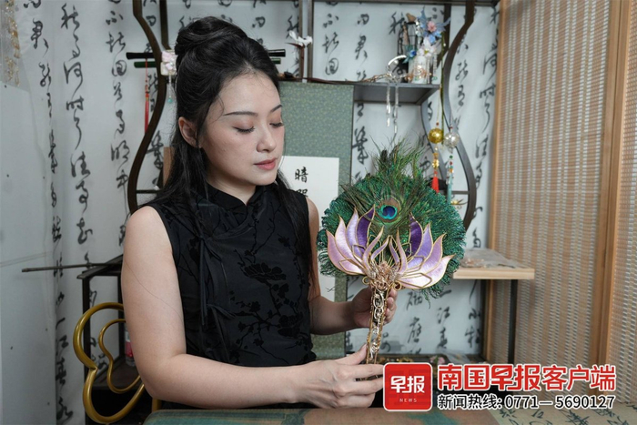 谢冲展示自己制作的孔雀翎。