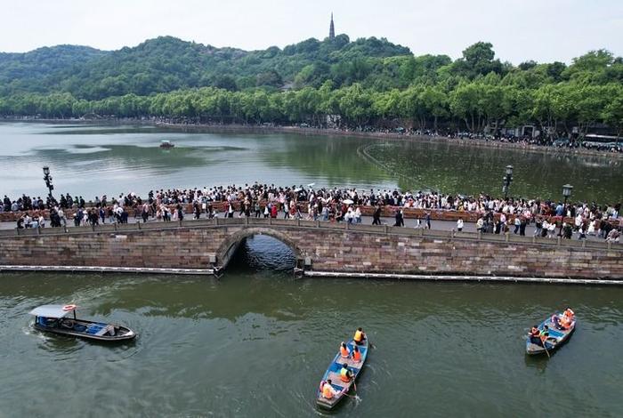 杭州西湖断桥上人流如织（2024年5月1日摄，无人机照片）。 新华社发（龙巍 摄）