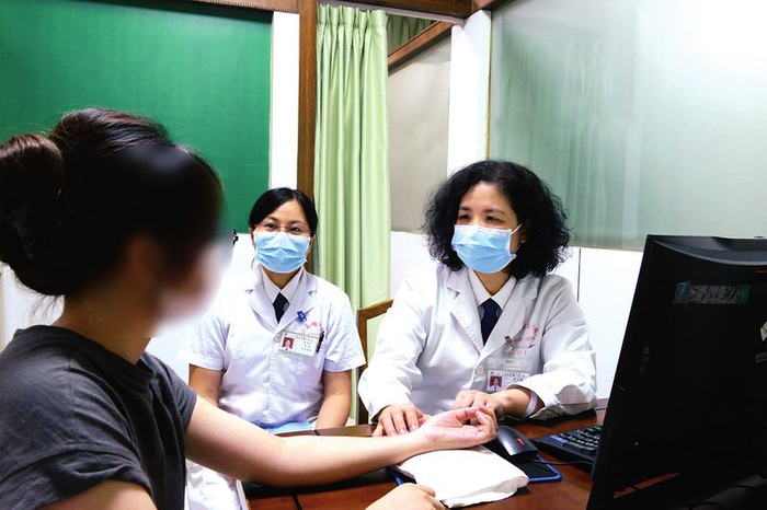     仁爱分院妇科主任陈文英为患者把脉。    （医院供图）