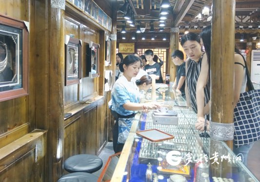游客在西江千户苗寨挑选银饰