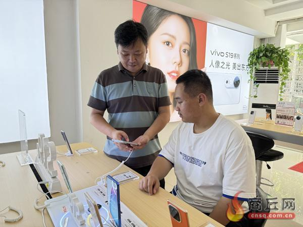 家长与孩子一起选购电子产品。记者 梁晓晨 摄