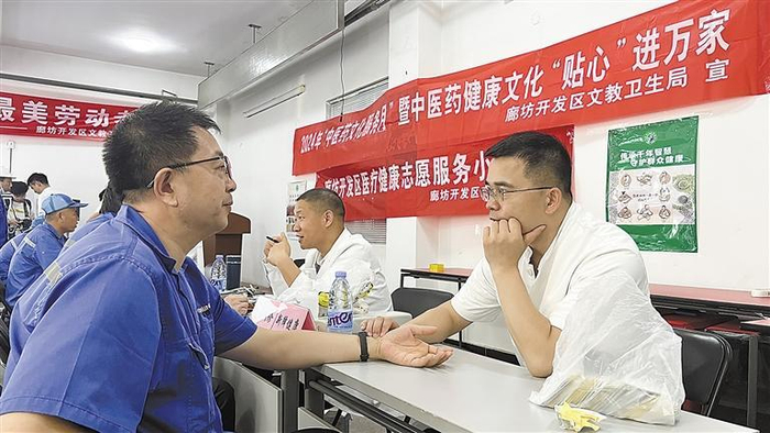     图为中医师为企业员工把脉问诊。    本报记者 马珉璐 本报通讯员 金秀丽 摄