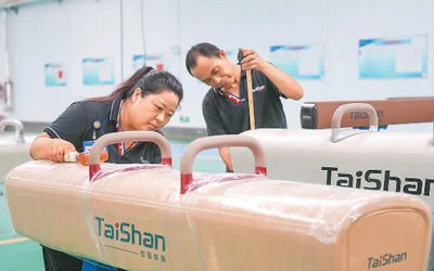 7月8日，在山东省泰山体育器材有限公司生产车间，工人在检测刚下线的鞍马。新华社记者 朱峥摄