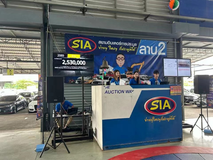 图注：2024年7月，曼谷市郊某个二手车拍卖场，工作人员正在拍卖卡车 摄影：刘丁