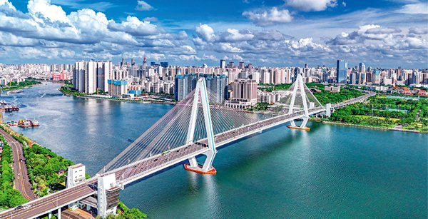 俯瞰海南省海口市海甸河入海口世纪大桥两岸，现代化建筑鳞次栉比，环境优美，海南自贸港建设中心城市发展优势凸显，生机勃发