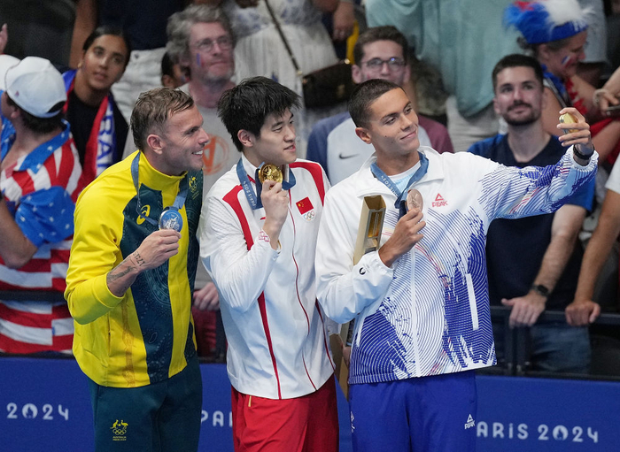 ↑冠军中国选手潘展乐（中）、亚军澳大利亚选手查默斯（左）与季军罗马尼亚选手波波维奇在颁奖仪式上。新华社记者 薛宇舸 摄