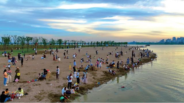 市民在龙子湖畔的金色沙滩玩耍。新华网发（金良巧 摄）