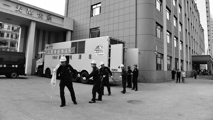         在丹东振安区九连城镇五纬路小学安置点，供电人员正在接通应急电源。受访者供图