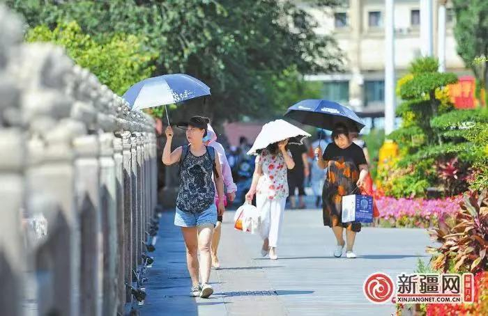 7月29日，在乌鲁木齐市西大桥，市民撑伞出行。乌鲁木齐晚报全媒体记者 雷婷摄