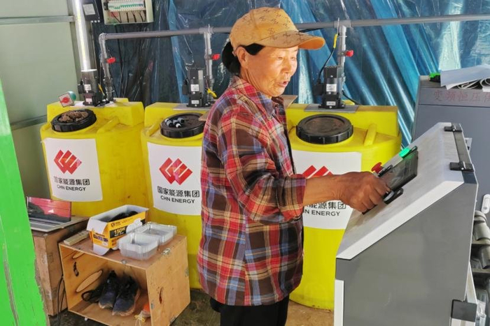 ▲当地村民正在操作喷淋系统为大棚作物浇水