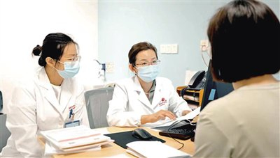 上海交通大学医学院附属国际和平妇幼保健院产前诊断中心主任吴怡（中）在接诊患者。