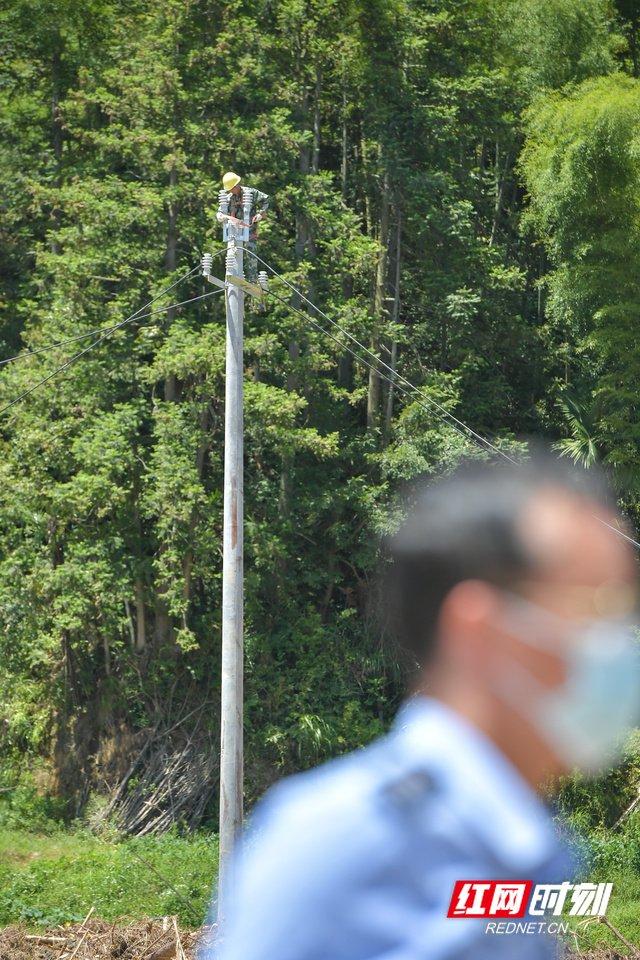 一个不经意的擦身而过，立于电线杆上的电力抢修人员显得格外高大。