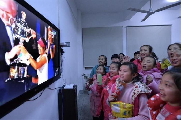   2014年李娜夺冠时，郑钦文（右一）在电视机前 （图源：新华社）