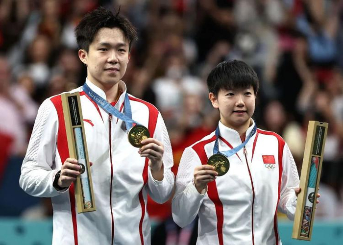 7月30日，夺得巴黎奥运会乒乓球混双冠军的中国组合王楚钦（左）/孙颖莎在颁奖仪式上。 新华社记者 王东震 摄