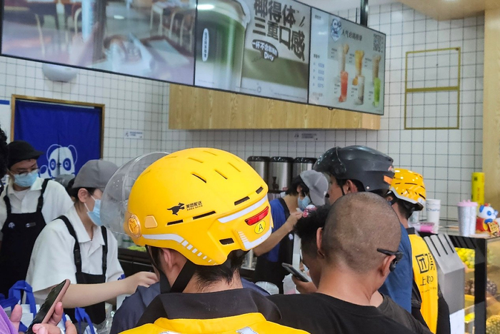 ▲立秋当天，北京一奶茶店内挤满自提顾客和外卖小哥（摄影/张悦）